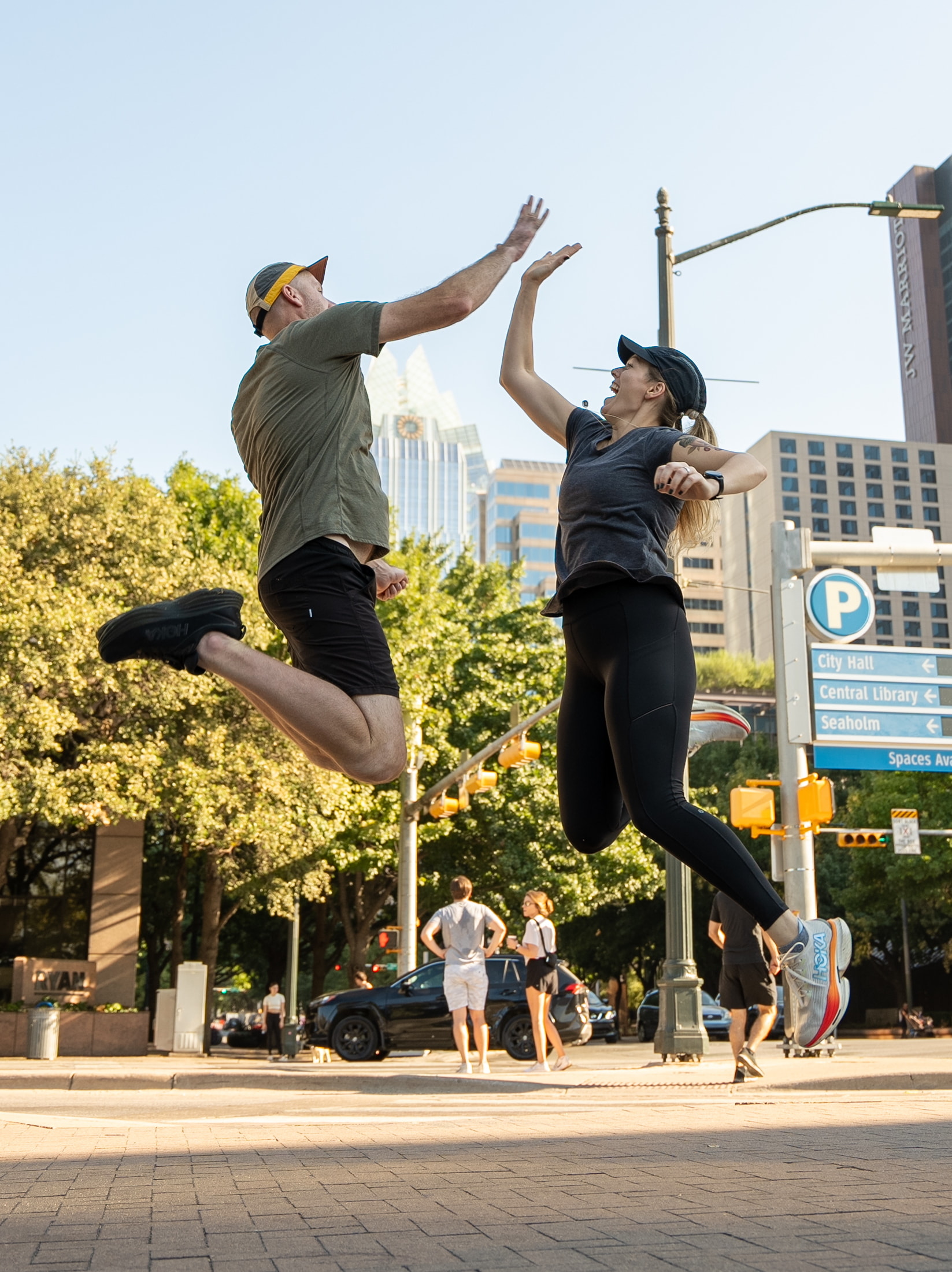 Two runners jumping in the air doing a high-five.